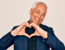 A man holding his hands in the shape of a heart.